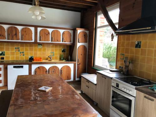 une cuisine avec des placards en bois et un comptoir en bois dans l'établissement Entre Caps et Marais la FERME, à Alembon