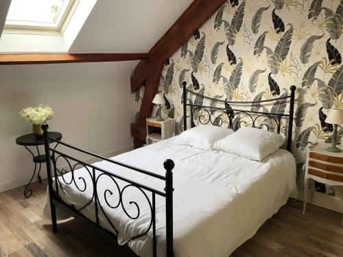 - une chambre avec un lit noir et du papier peint floral dans l'établissement Entre Caps et Marais la FERME, à Alembon