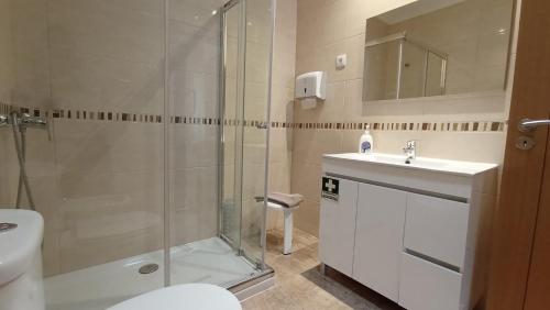 a bathroom with a shower and a sink and a toilet at Antiga Casa do Forno in Vidago