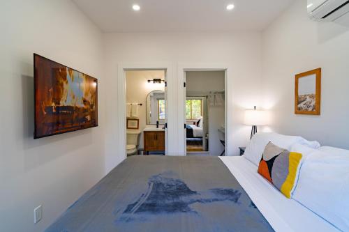a white bedroom with a bed and a painting on the wall at Fern House South Park Craftsman in San Diego