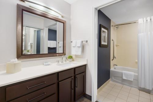 a bathroom with a sink and a mirror and a tub at Residence Inn Boston Franklin in Franklin