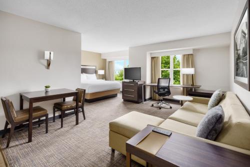 a hotel room with a bed and a living room at Residence Inn Boston Franklin in Franklin