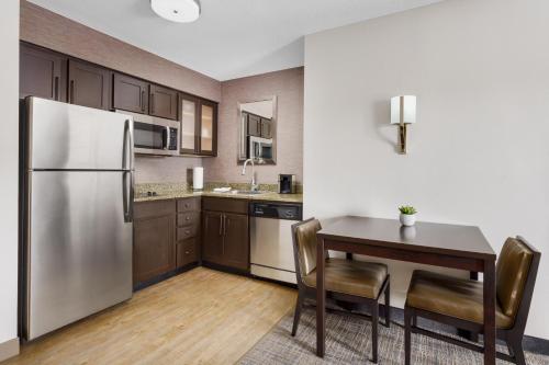 a kitchen with a table and a refrigerator at Residence Inn Boston Franklin in Franklin