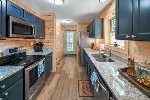 a kitchen with blue cabinets and granite counter tops at Goss at Lake Lure in Lake Lure