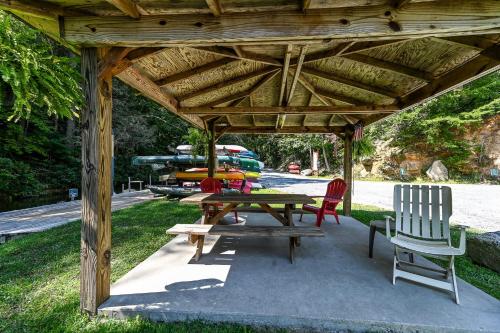 a wooden pavilion with a picnic table and chairs at Goss at Lake Lure in Lake Lure
