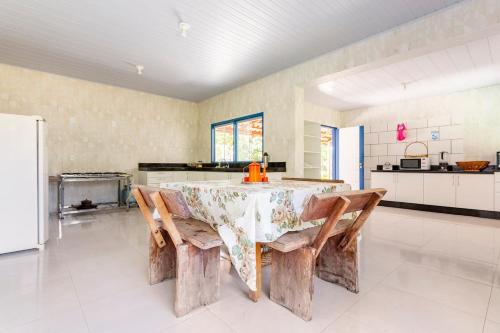 una cucina con tavolo, sedie e frigorifero di Estância Morro Do Frota a Pirenópolis