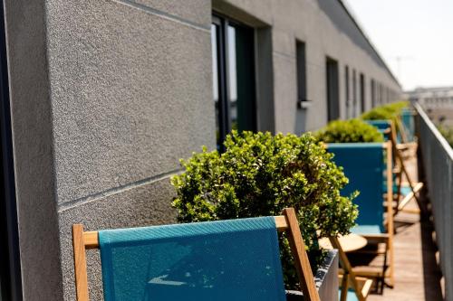 a row of chairs and plants next to a building at Motel One Köln-Mediapark in Cologne