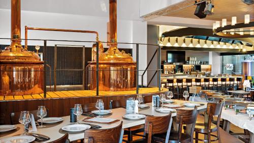 a restaurant with wooden tables and chairs and lights at Hey Lou Hotel Frankfurt Airport in Kelsterbach