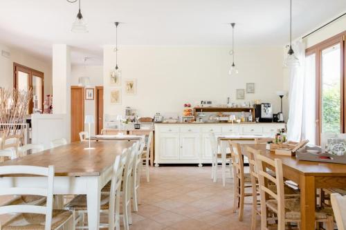 eine Küche und ein Esszimmer mit Holztischen und Stühlen in der Unterkunft Agriturismo Ai Carpini in Marcon