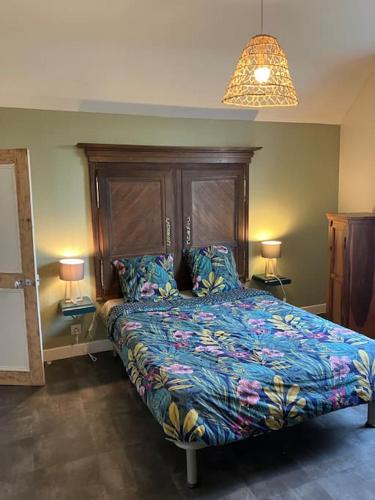 a bedroom with a bed with a colorful bedspread and two lamps at *•*•Nouveau*•*• Chez Mirabelle in Belleville-sur-Meuse