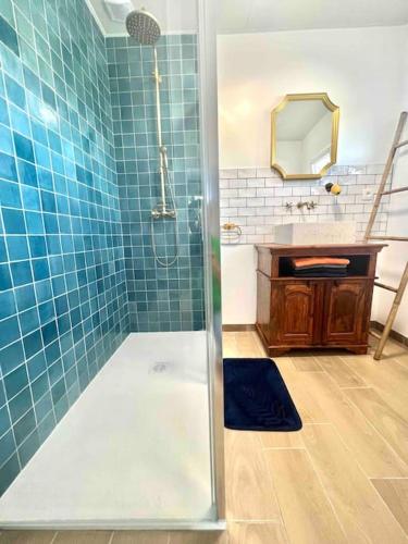 La salle de bains est pourvue de carrelage bleu, d'une douche et d'un lavabo. dans l'établissement *•*•Nouveau*•*• Chez Mirabelle, à Belleville-sur-Meuse