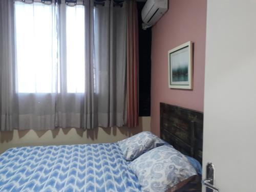 a bedroom with a bed with a blue comforter at Apartamento Gonzaga in Santos