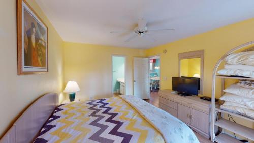 Schlafzimmer mit einem Bett und einem Flachbild-TV in der Unterkunft Relax in Style 2BR True Blue Resort Villa in Pawleys Island