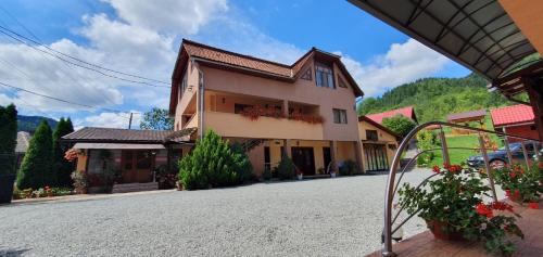 a house on a street with a building at Pensiunea Apuseni in Vidra