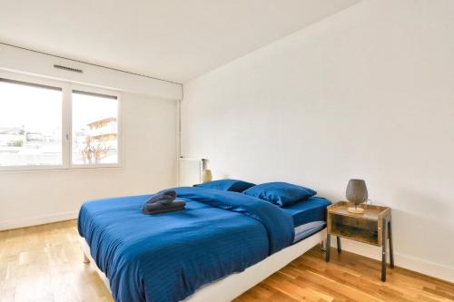 ein Schlafzimmer mit einem blauen Bett und einem Fenster in der Unterkunft Appartement Quartier Bastille in Paris
