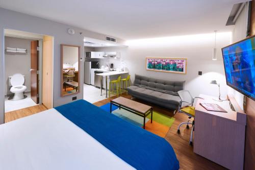 - une chambre avec un grand lit et un salon dans l'établissement City Express Suites by Marriott Playa del Carmen, à Playa del Carmen