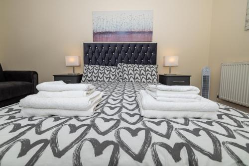 sypialnia z dużym łóżkiem z białymi kocami i poduszkami w obiekcie Two bed Apartment near Canary Wharf w Londynie