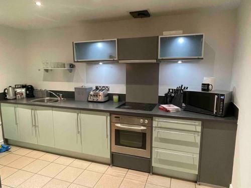 eine Küche mit einer Arbeitsplatte und einer Mikrowelle in der Unterkunft Stylish 2 Bed/Bath Apartment in Birmingham
