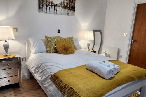 a bedroom with a white bed with a yellow blanket at Stylish 2 Bed/Bath Apartment in Birmingham