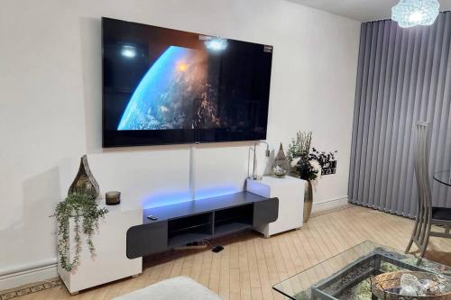 a living room with a large flat screen tv on a wall at Stylish 2 Bed/Bath Apartment in Birmingham