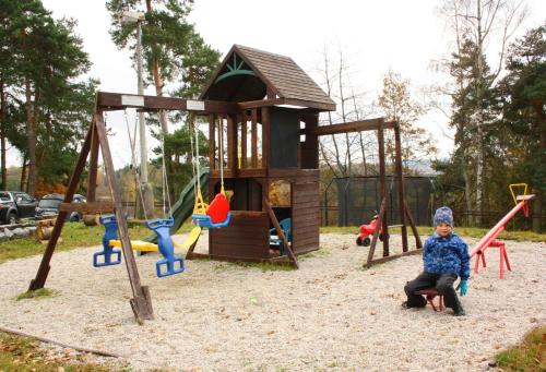 a child sitting on a swing in a playground at Nad rybníkem Hnačov - rodinný rekreační areál in Hnačov