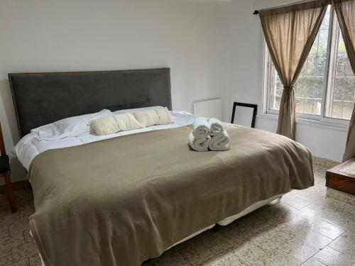 un dormitorio con una cama con dos animales de peluche en Quinta La Milagrosa en José C. Paz