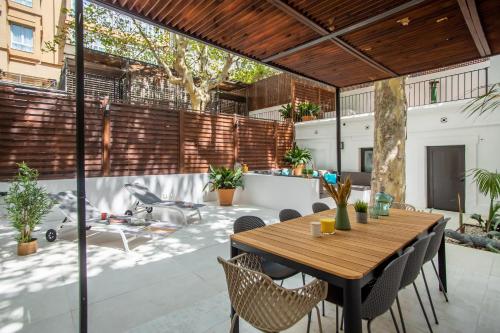 an outdoor patio with a wooden table and chairs at Tendency Apartments 9 in Barcelona