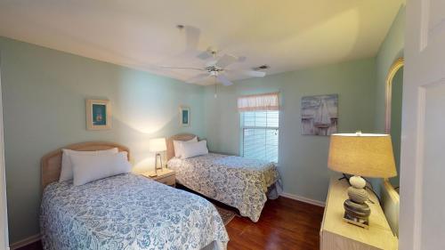 a bedroom with two beds and a ceiling fan at Golf Course Oasis Inviting 3BRVilla Pawleys Island in Pawleys Island