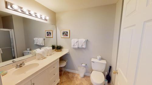 a bathroom with a sink and a toilet and a mirror at Golf Course Oasis Inviting 3BRVilla Pawleys Island in Pawleys Island