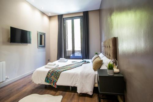 a bedroom with a bed and a tv on the wall at Tendency Apartments 9 in Barcelona