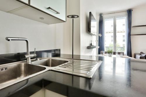 eine Küche mit einer Spüle und einer Arbeitsplatte aus Edelstahl in der Unterkunft Appartement Quartier Champs-Élysées 4 in Paris