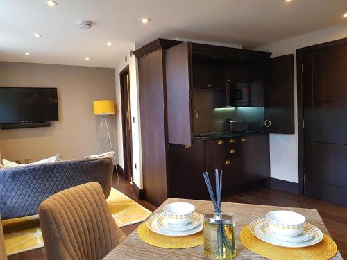 a living room with a table with two dishes on it at The Queens Head, Parkside apartment 2 in Burley in Wharfedale
