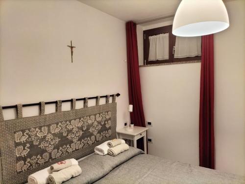 1 dormitorio con 1 cama con toallas en B&B il Melograno, en Paulilatino