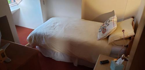 a bedroom with a white bed with a pillow at Weaver's House B and B in Cardiff