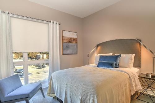 ein Schlafzimmer mit einem Bett, einem Stuhl und einem Fenster in der Unterkunft 45 Asheland Avenue Unit 306 in Asheville