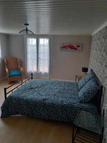 um quarto com uma cama, uma cadeira e uma janela em La Croix de la Roche em Trémuson