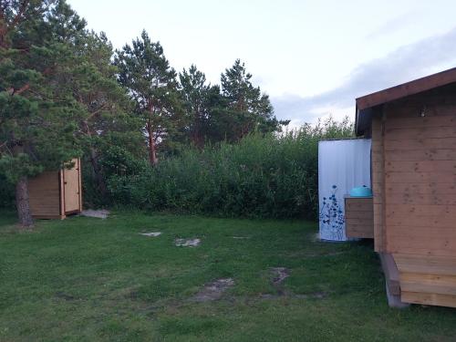 a yard with a shed and a refrigerator in the grass at Treimani Meremaja in Treimani