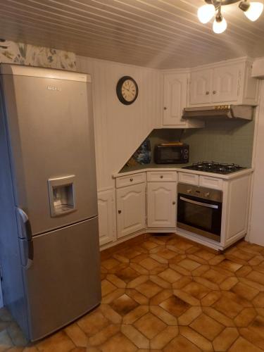 Il comprend une cuisine équipée d'un réfrigérateur et d'une horloge murale. dans l'établissement La Croix de la Roche, à Trémuson