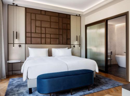 a bedroom with a large white bed and a tub at Radisson Collection Hotel, Magdalena Plaza Sevilla in Seville