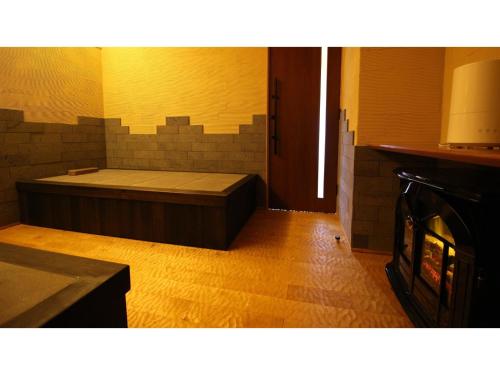 een kamer met een bed naast een open haard bij Unazuki Onsen Sanyanagitei - Vacation STAY 06553v in Kurobe