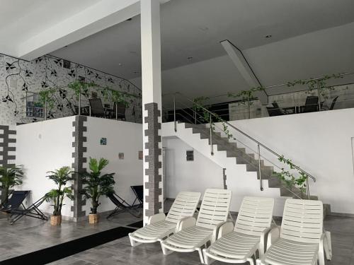a group of white chairs in a room with stairs at Resort SPA Clisura Dunarii in Eşelniţa
