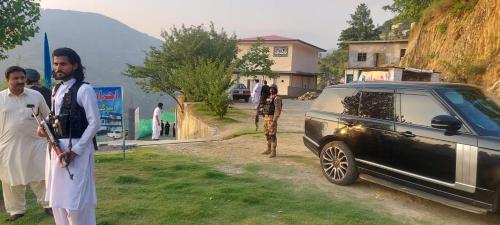 a couple of men standing next to a car at Ihram Hotel And Guest House in Swat
