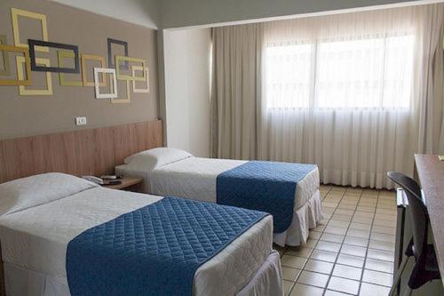 מיטה או מיטות בחדר ב-Monza Palace Hotel