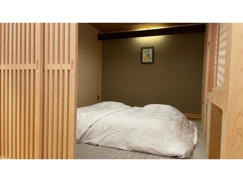 a bed with white sheets in a bedroom at Unazuki Onsen Sanyanagitei - Vacation STAY 06557v in Kurobe