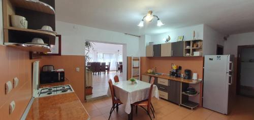 a kitchen with a table and a kitchen with a refrigerator at Pensiunea Apuseni in Vidra