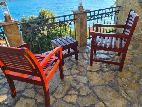 - deux chaises et un banc sur une terrasse donnant sur l'océan dans l'établissement HARMONY Apartments, à Ulcinj