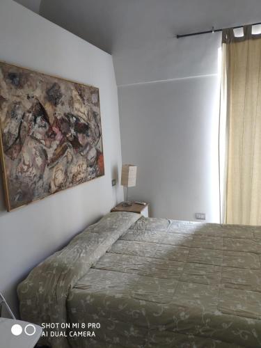1 dormitorio con 1 cama y una pintura en la pared en Taverna Garibaldi Casa Lucia, en Minervino Murge