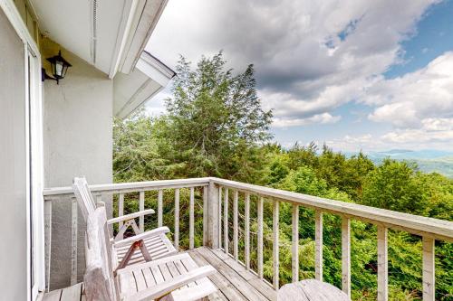 a balcony with two chairs and a view of the mountains at Cozy Mountain Nest in Sugar Mountain