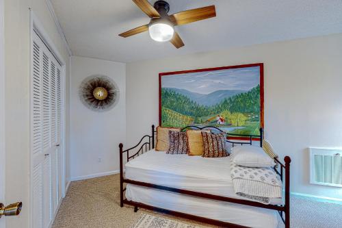 a bedroom with a bed with a painting on the wall at Cozy Mountain Nest in Sugar Mountain
