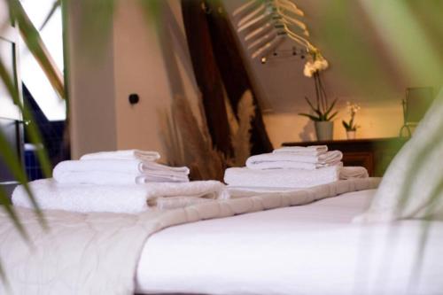 a stack of towels sitting on top of a bed at Maison Marcks Champagne in Ay